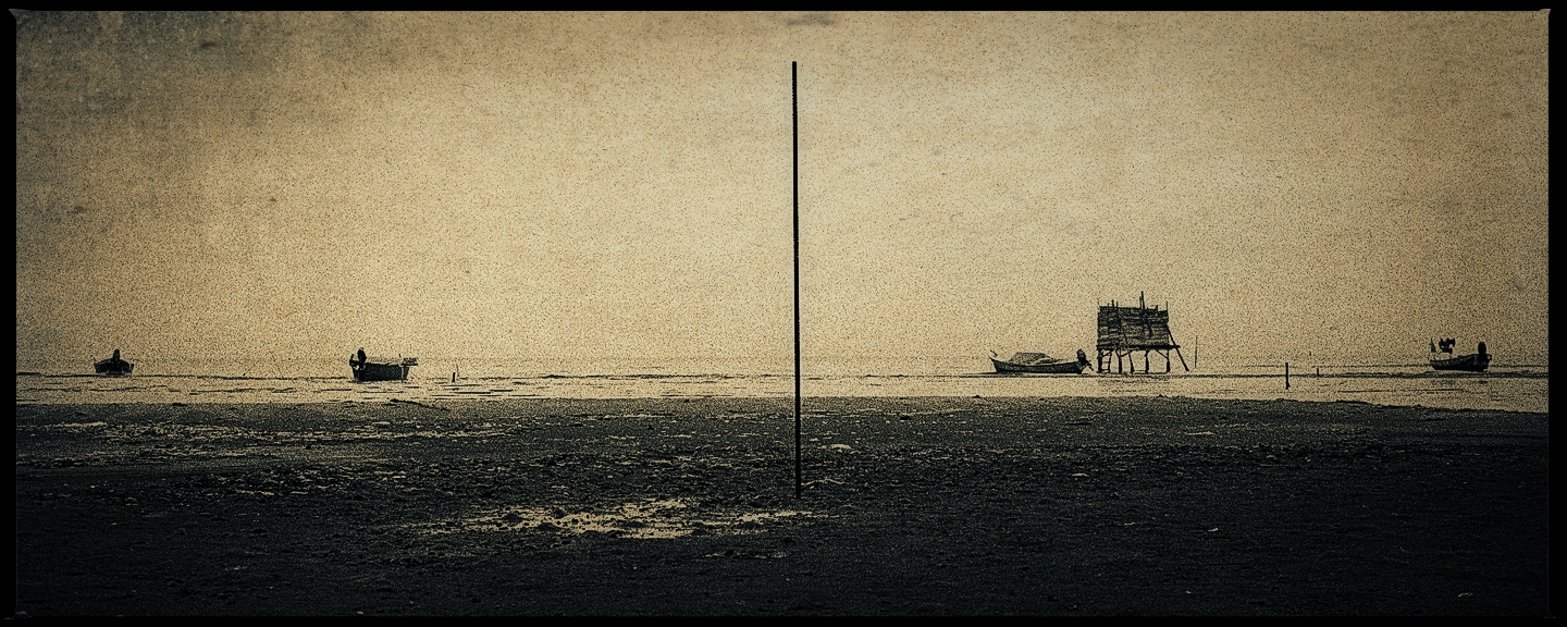 Small boats and a fishing structure along a quiet horizon